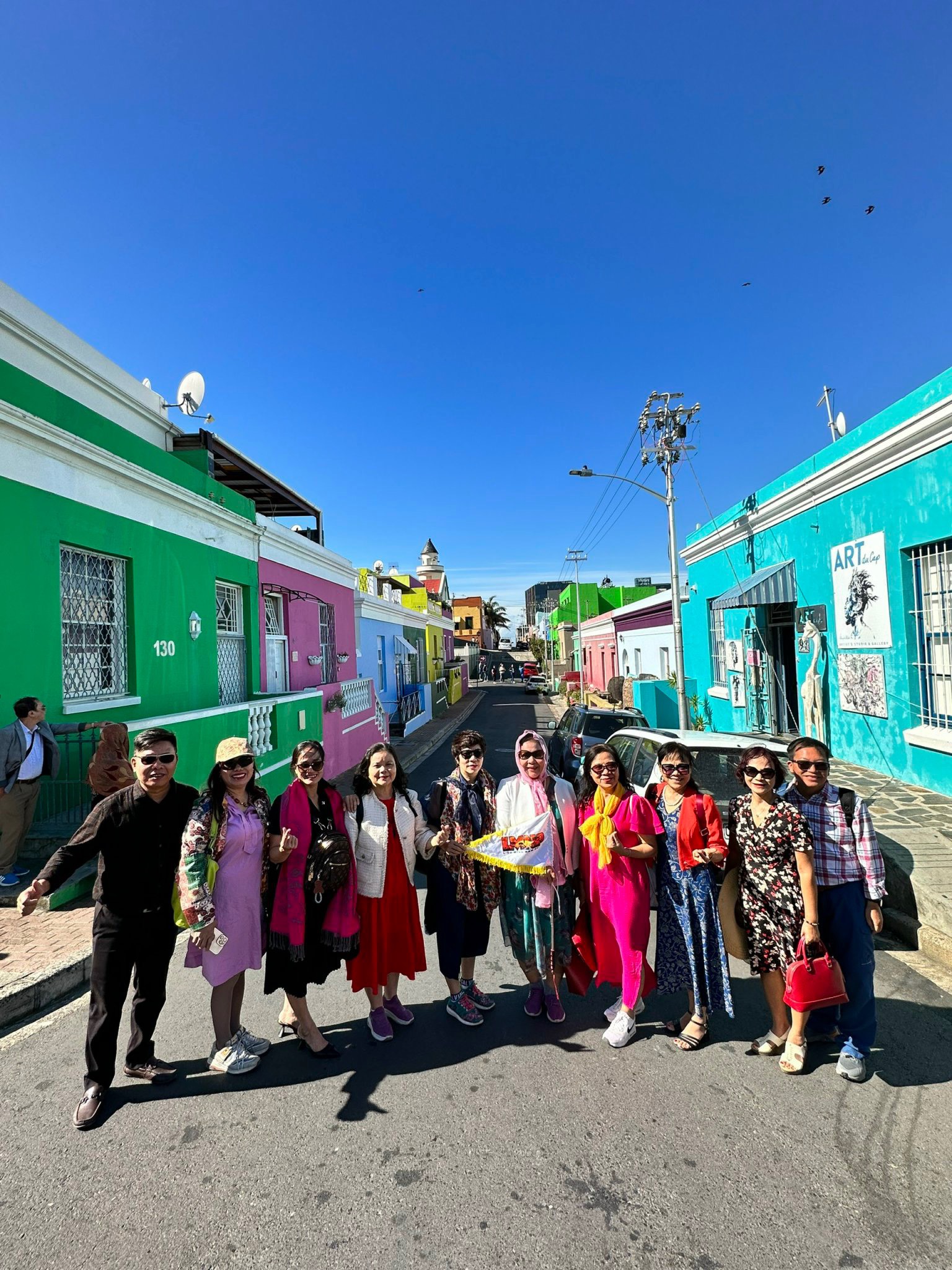 Đoàn khách chụp ảnh cùng dãy nhà sắc màu tại Bo-Kaap trong lịch trình tour Nam Phi